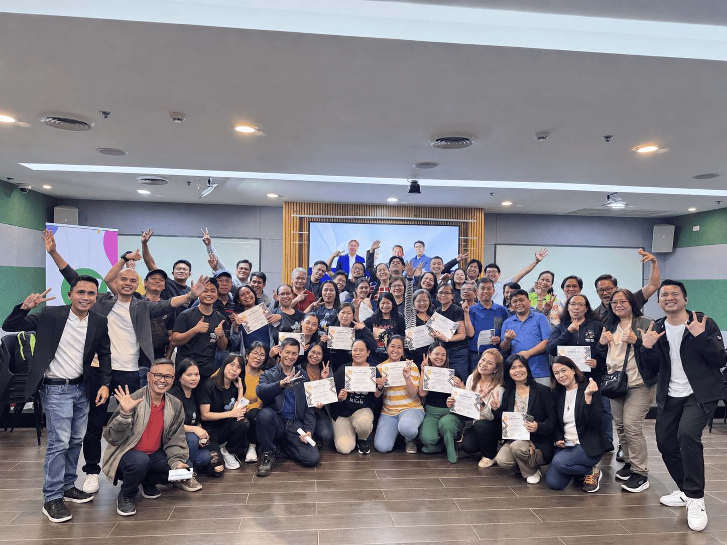Workshop participants celebrating together while holding their certificates